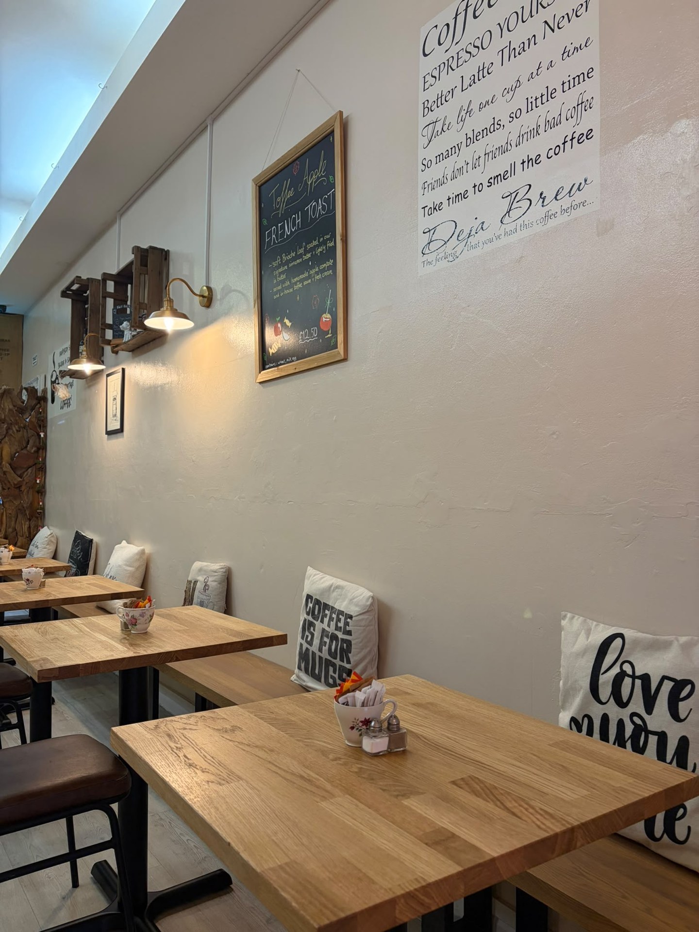Wooden tables and cushioned bench seating along the freshly painted café wall
